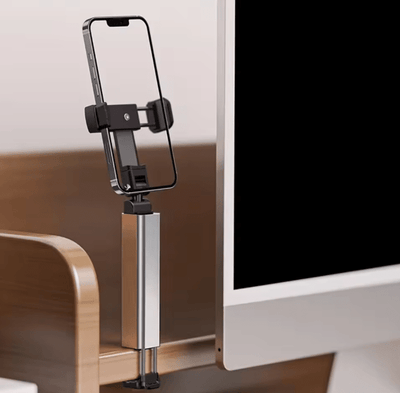 Tekvyn FoldGrip phone holder clamped to a desk holding a phone at eye level